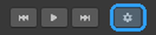 The cog beside the transport buttons, above the timeline.